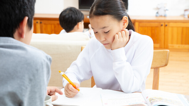 子供の勉強をみるお父さん