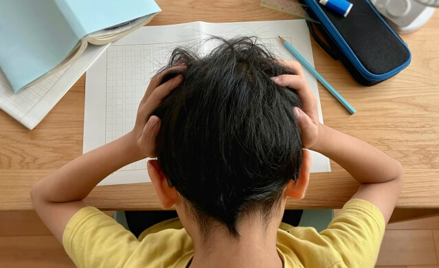 勉強ができなくて頭をかかえる小学生